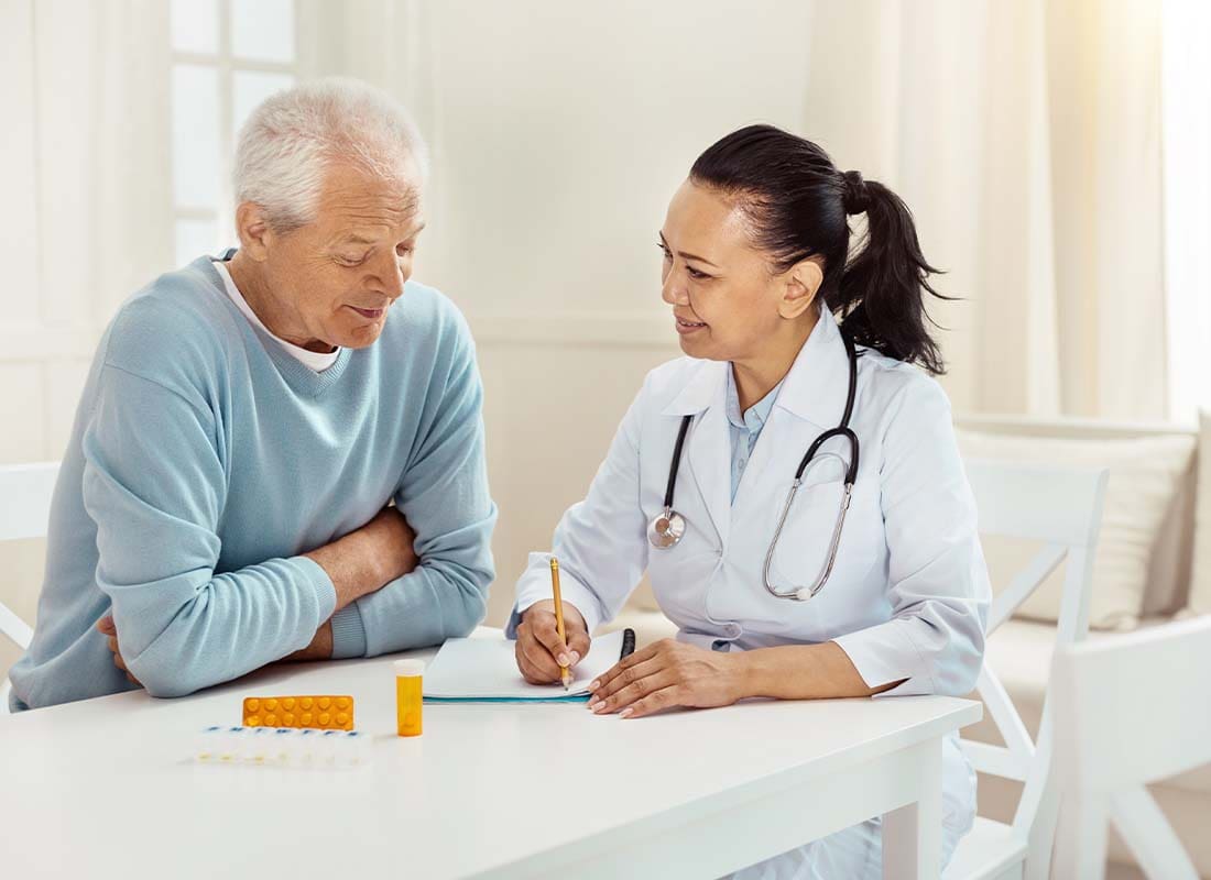 Medicare Part D - Smiling and Encouraging Doctor Takes Notes